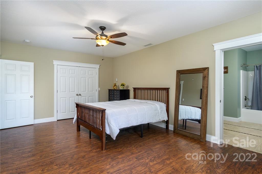 225 Nut Hatch Loop Arden, NC 28704 - Photo 31 of 48 a bedroom with a bed and a chandelier