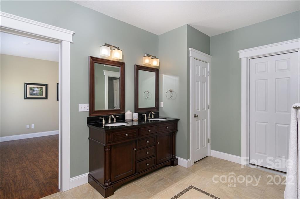225 Nut Hatch Loop Arden, NC 28704 - Photo 33 of 48 a bathroom with a double vanity sink and a mirror