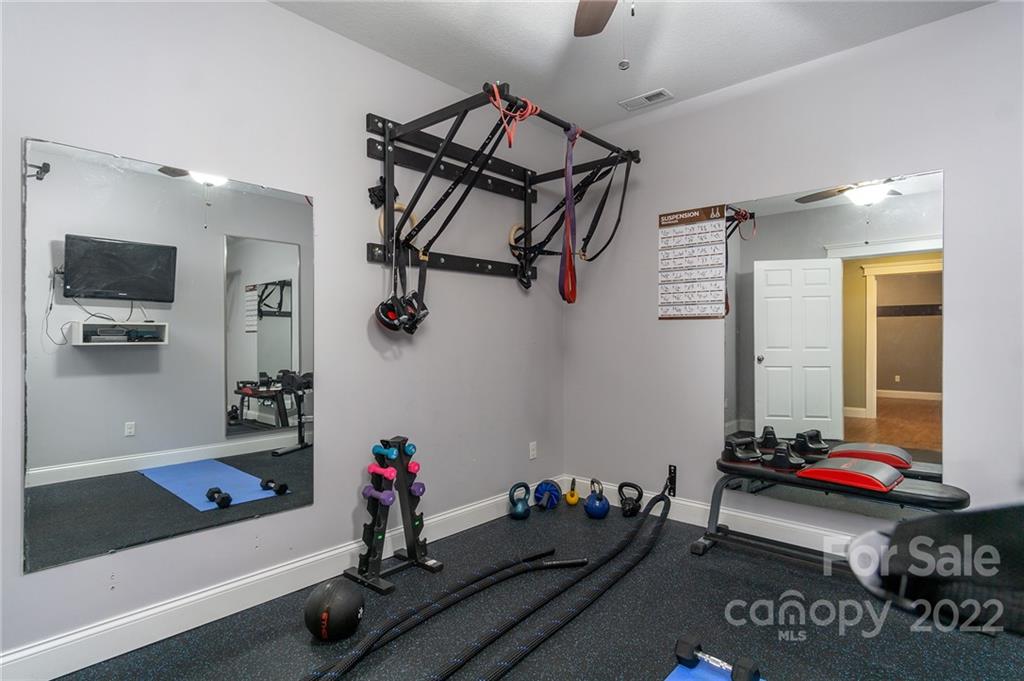 225 Nut Hatch Loop Arden, NC 28704 - Photo 34 of 48 a room with gym equipment and a flat screen tv
