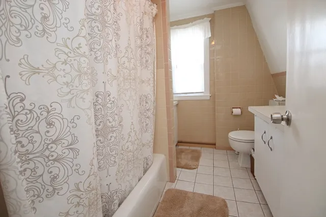 a bathroom with a toilet and a shower curtain