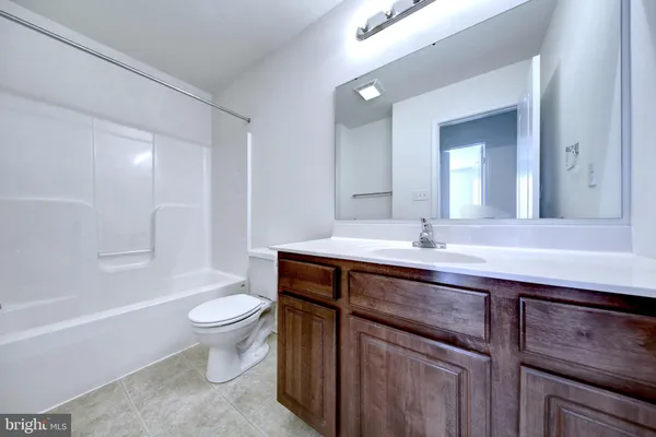 a bathroom with a sink a toilet a mirror and bathtub