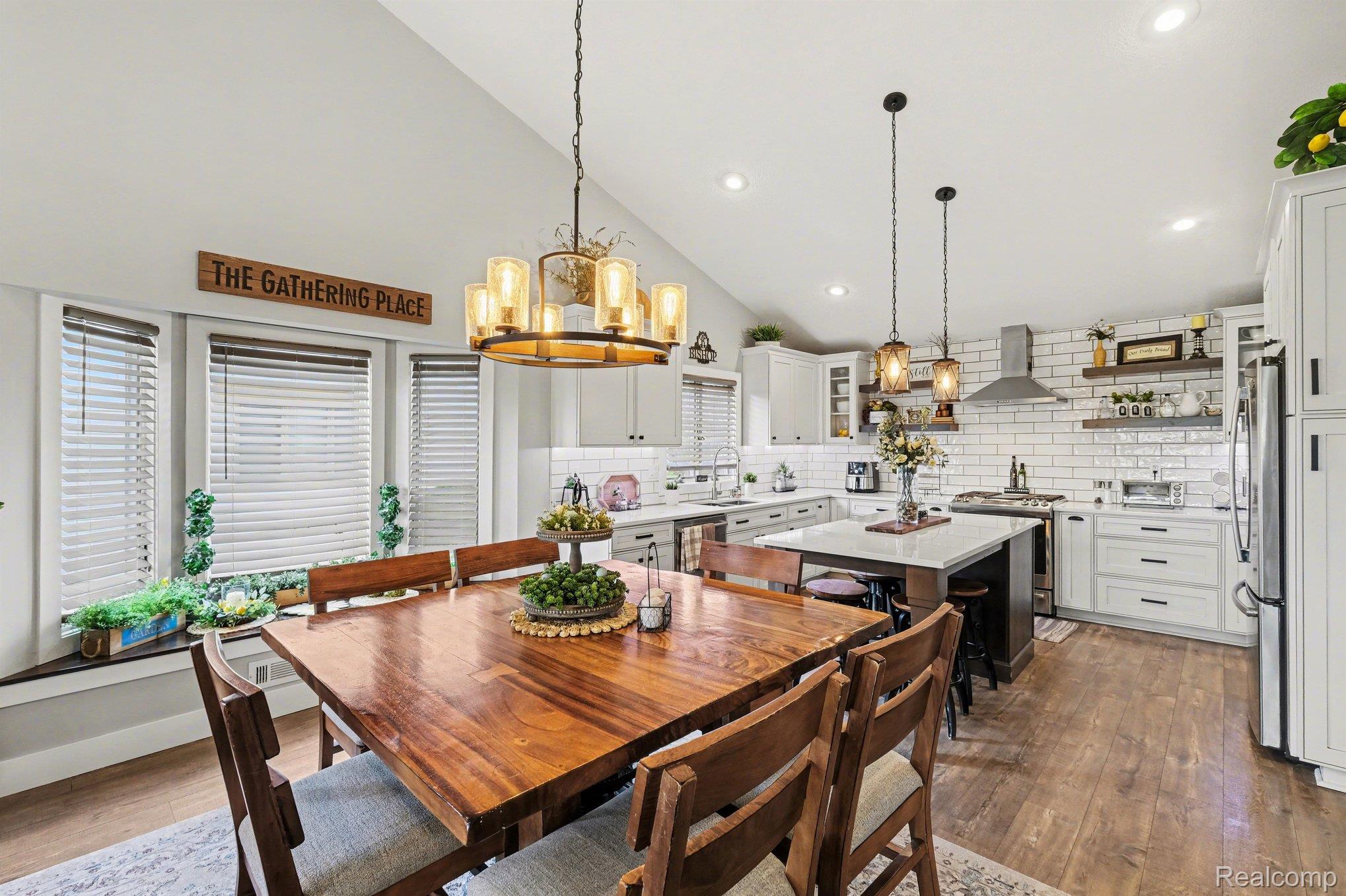 9084 Copper Ridge Drive Davison, MI 48423 - Photo 17 of 42 Dining space featuring lofted ceiling, dark wood finished floors, and a chandelier