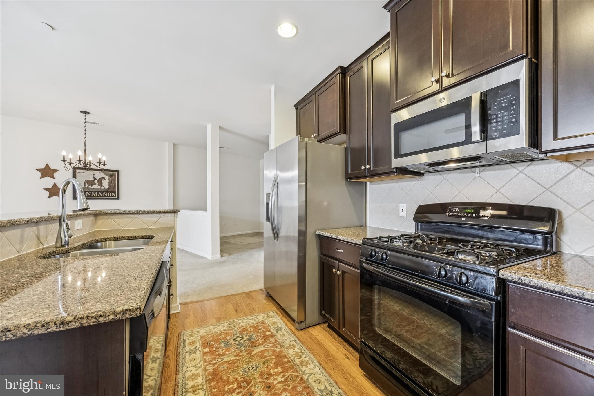 427 Carson Terrace Huntingdon Valley, PA 19006 - Photo 2 of 19 a kitchen with stainless steel appliances granite countertop a stove microwave and sink