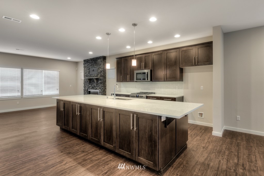 3920 242nd Street Southeast, Unit PT 4 Bothell, WA 98021 - Photo 6 of 23 a kitchen with stainless steel appliances granite countertop a sink a stove and a wooden floors
