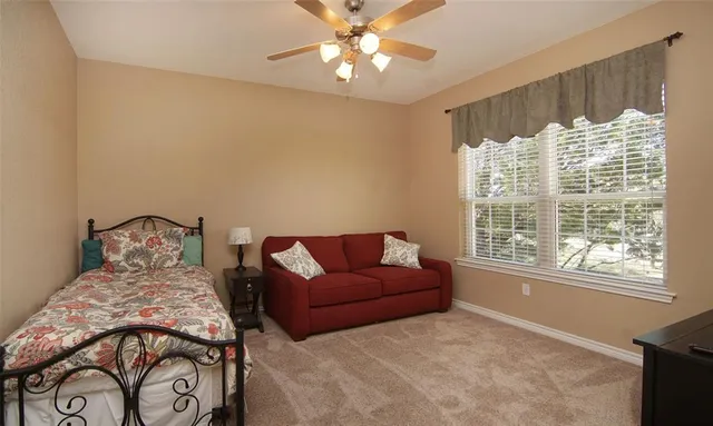 a bedroom with furniture and a large window