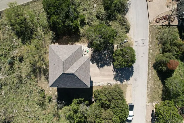 an aerial view of a house with a yard and lake view