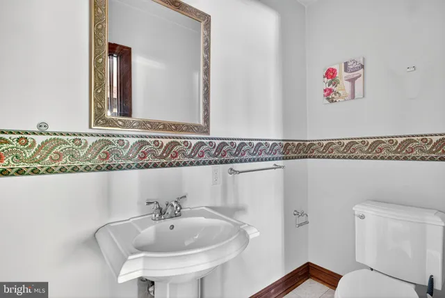 a view of a hallway with wooden floor and paintings on the wall