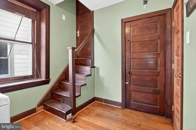 a view of a hallway with wooden floor and a living room