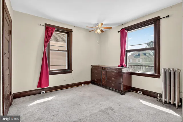 a view of an empty room with cabinet and a bathroom