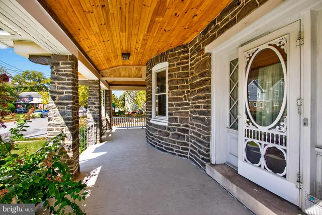 a view of an entryway with wooden floor staircase and a living room