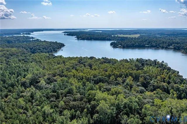 an aerial view of a house with a yard and lake view