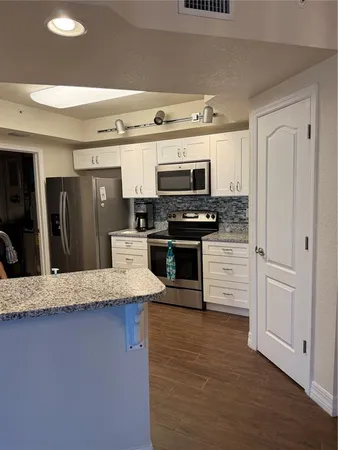 a kitchen with stainless steel appliances a stove a microwave a sink and cabinets