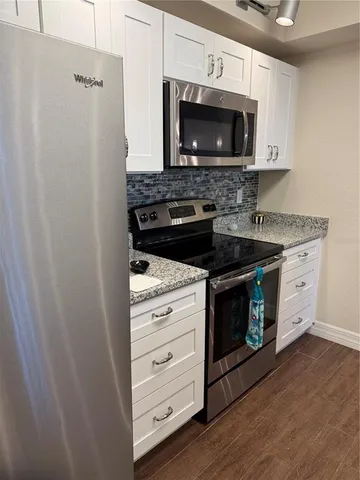 a kitchen with stainless steel appliances granite countertop a sink stove and cabinets