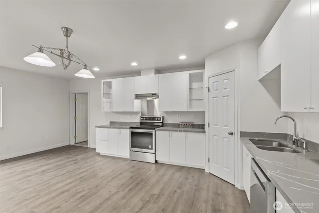 a kitchen with stainless steel appliances granite countertop a sink stove and refrigerator