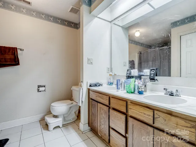 a bathroom with a granite countertop toilet sink and mirror