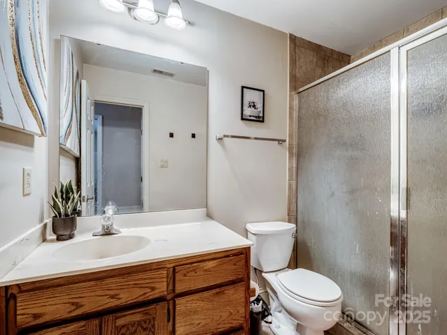 a bathroom with a sink toilet vanity and shower