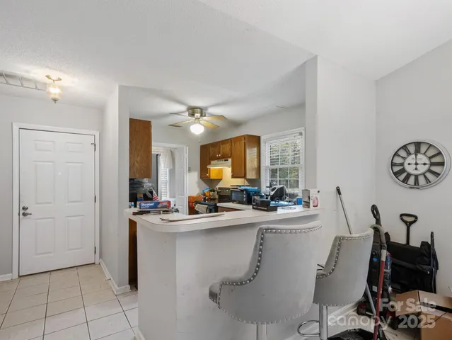 a room with a table chairs and a refrigerator