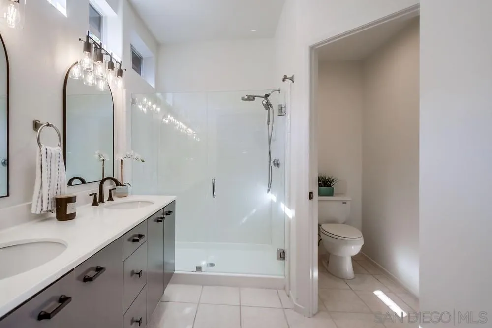 12490 Heatherton Court, Unit 10 San Diego, CA 92128 - Photo 20 of 39 a bathroom with a double vanity sink toilet and shower