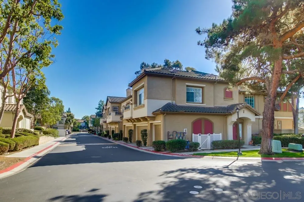 12490 Heatherton Court, Unit 10 San Diego, CA 92128 - Photo 2 of 39 a front view of a house with a yard and garage