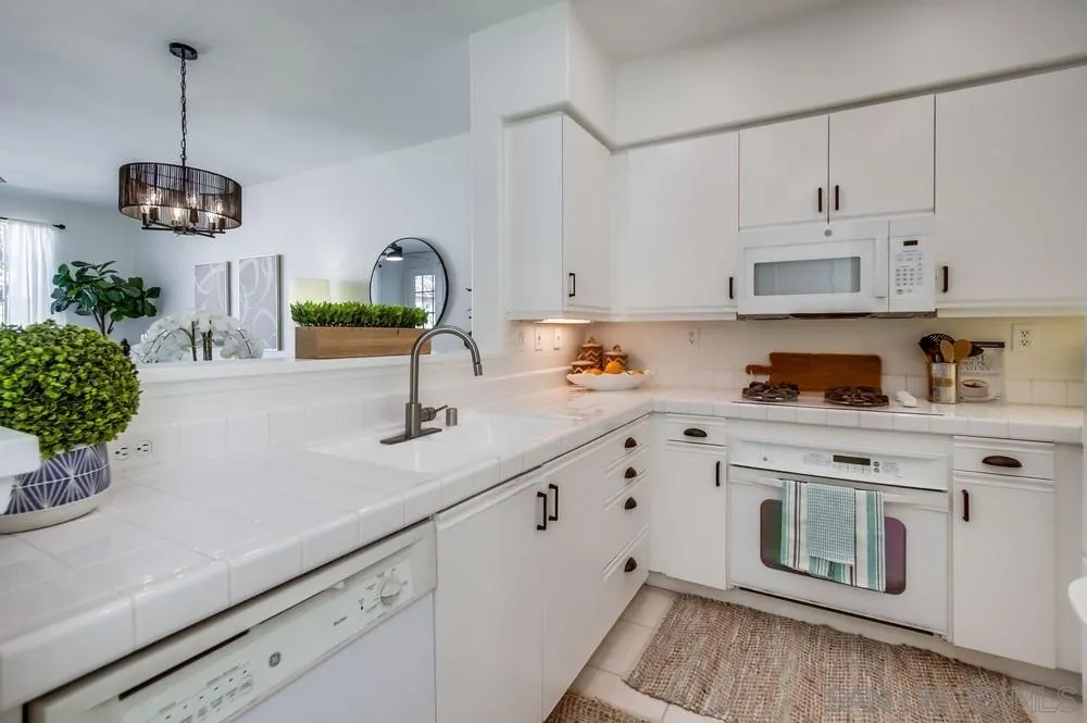 12490 Heatherton Court, Unit 10 San Diego, CA 92128 - Photo 24 of 39 a kitchen with stainless steel appliances granite countertop a sink a stove and white cabinets