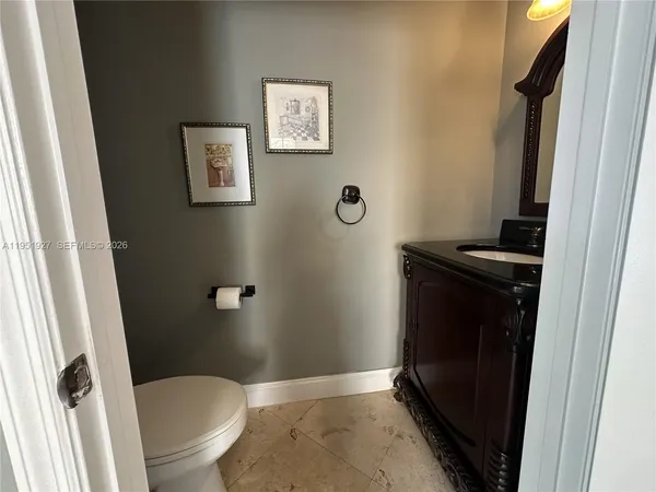 a bathroom with a granite countertop toilet and a sink