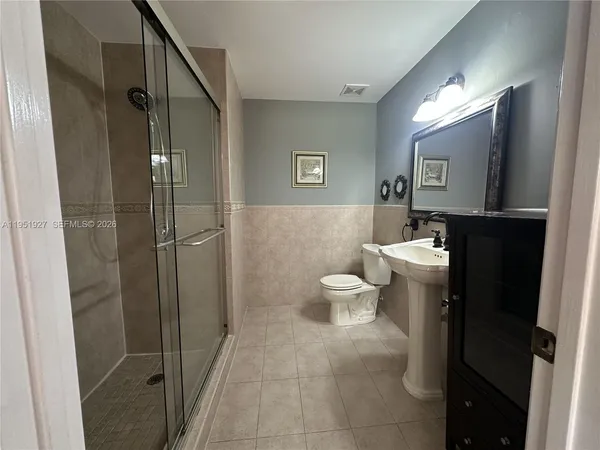 a bathroom with a toilet a sink and shower