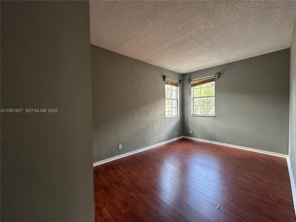 an empty room with windows and closet