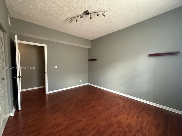 an empty room with wooden floor and closet