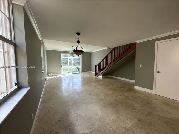 an empty room with windows and chandelier