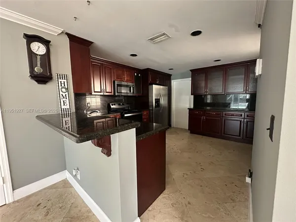 a kitchen with stainless steel appliances granite countertop a refrigerator and a stove top oven