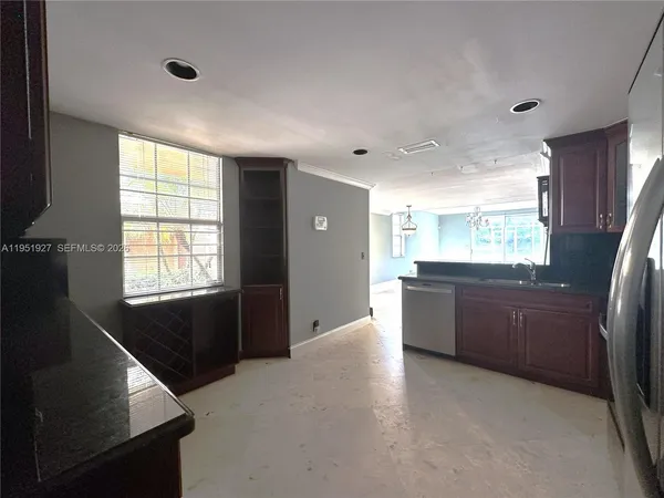 a large kitchen with a window and refrigerator