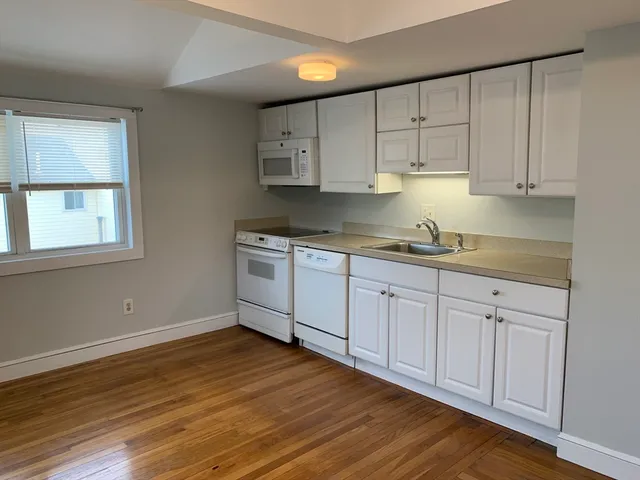 a kitchen with stainless steel appliances granite countertop a sink a stove a microwave and cabinets