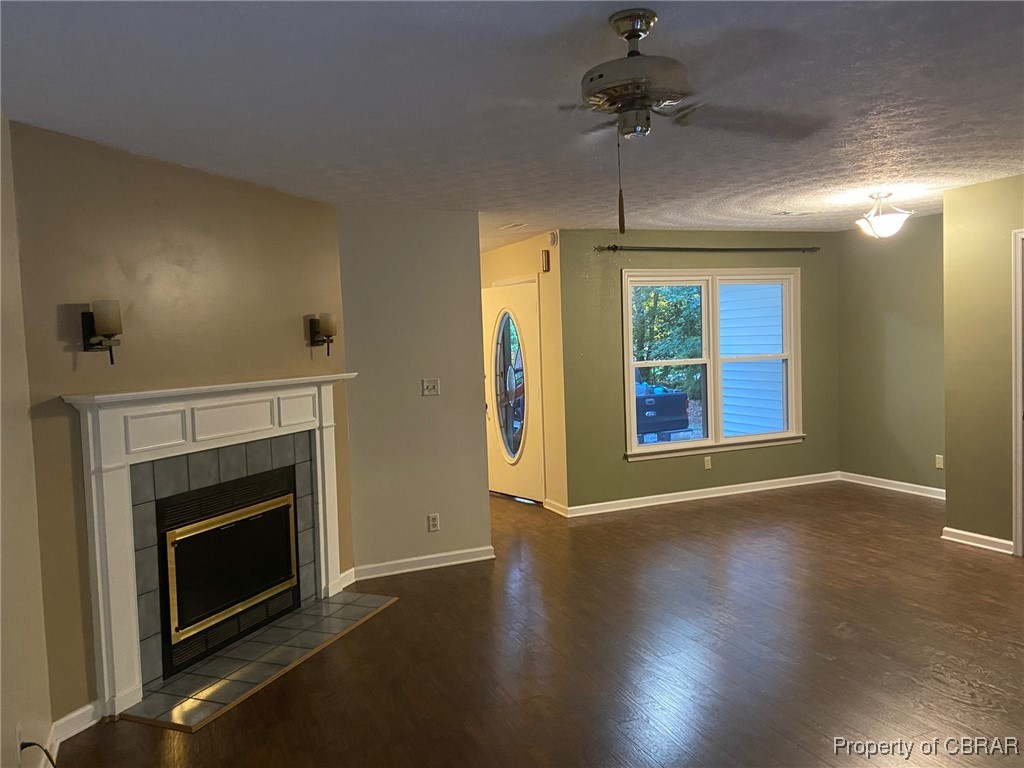 7944 Terrapin Cove Road Gloucester Point, VA 23062 - Photo 11 of 33 Unfurnished living room featuring a textured ceiling, ceiling fan, dark hardwood / wood-style flooring, and a tile fireplace