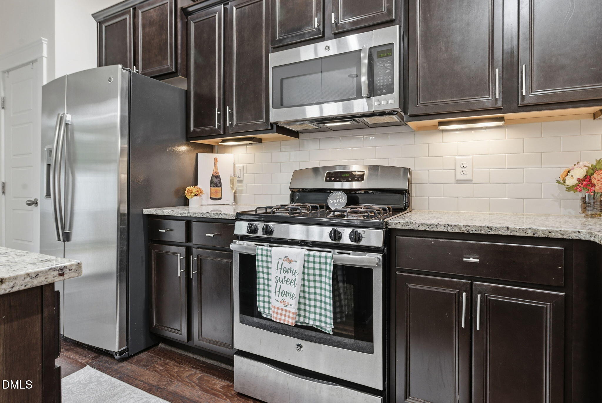 7851 Allscott Way Raleigh, NC 27612 - Photo 19 of 74 a kitchen with stainless steel appliances granite countertop a stove microwave and refrigerator