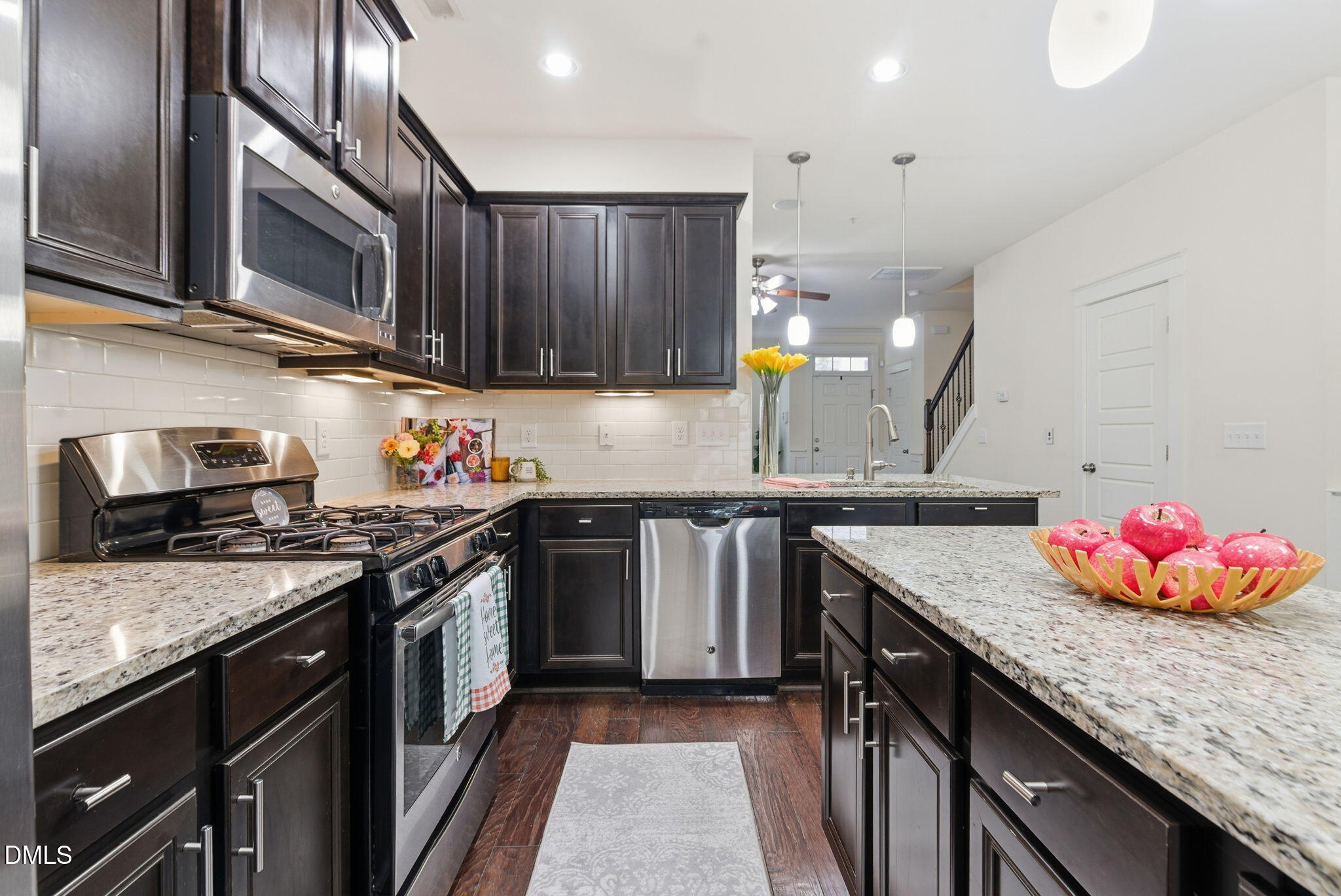 7851 Allscott Way Raleigh, NC 27612 - Photo 36 of 74 a kitchen with granite countertop a sink cabinets and stainless steel appliances