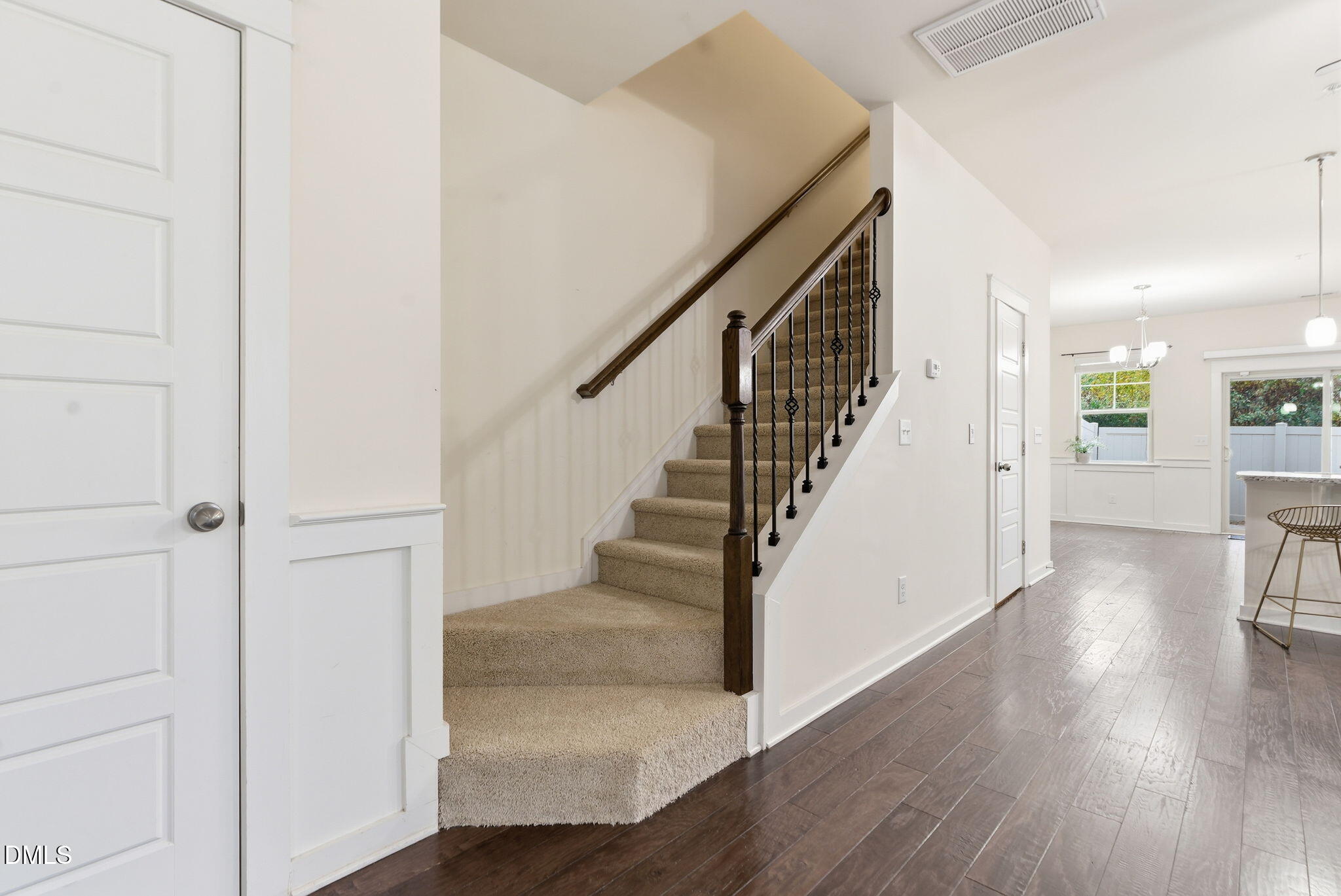 7851 Allscott Way Raleigh, NC 27612 - Photo 55 of 74 a view of a hallway with wooden floor stairs and a livingroom view