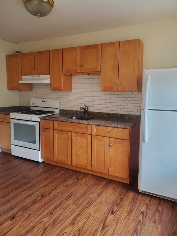 11 Victory Road, Unit 27 Boston, MA 02122 - Photo 1 of 16 a kitchen with wooden floors and white cabinets