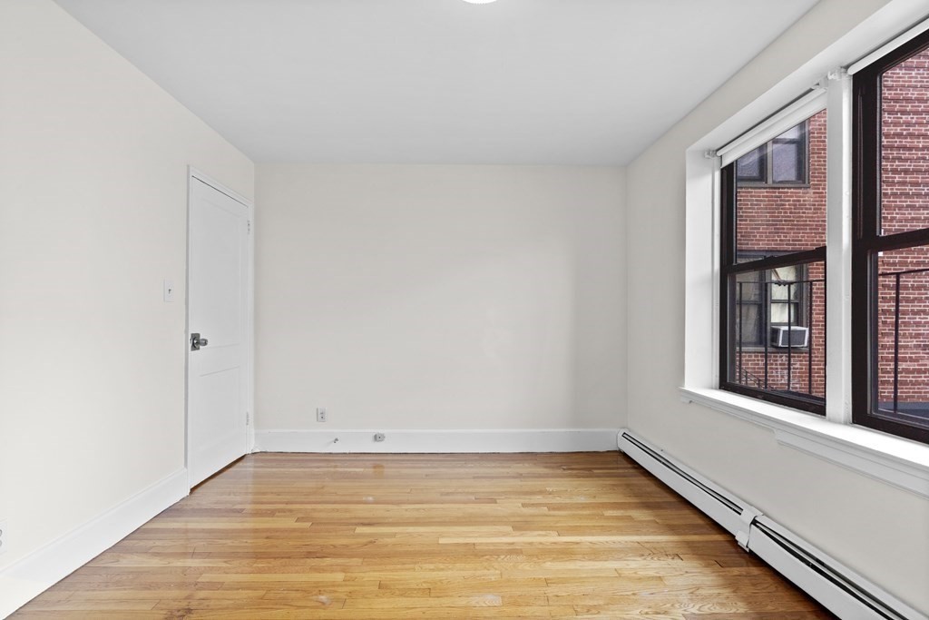 11 Victory Road, Unit 27 Boston, MA 02122 - Photo 6 of 16 a view of an empty room with wooden floor and a window
