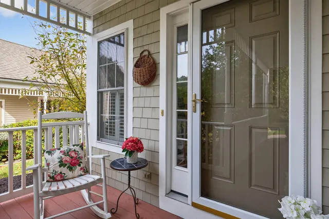 a front view of a house with outdoor seating and flowers