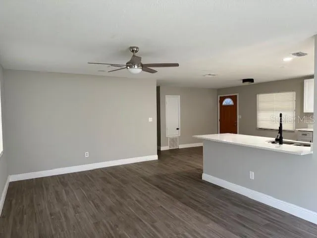 a view of an empty room with window and wooden floor