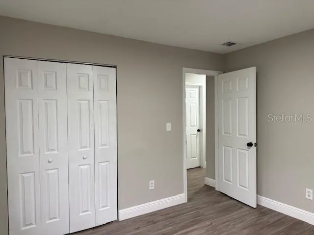 a view of empty room with wooden floor