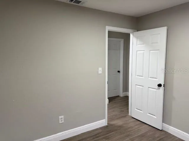 a view of an empty room with wooden floor