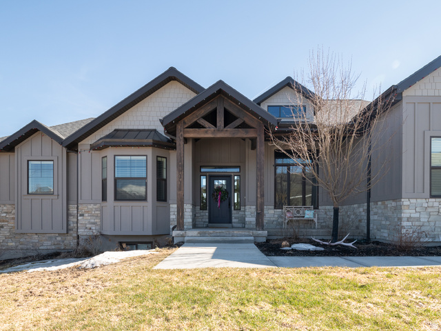 641 West 500 South Midway, UT 84049 - Photo 4 of 52 Craftsman-style exterior featuring a prominent timber-frame entry, board and batten siding, stone accents, dark-framed windows, and a bay window