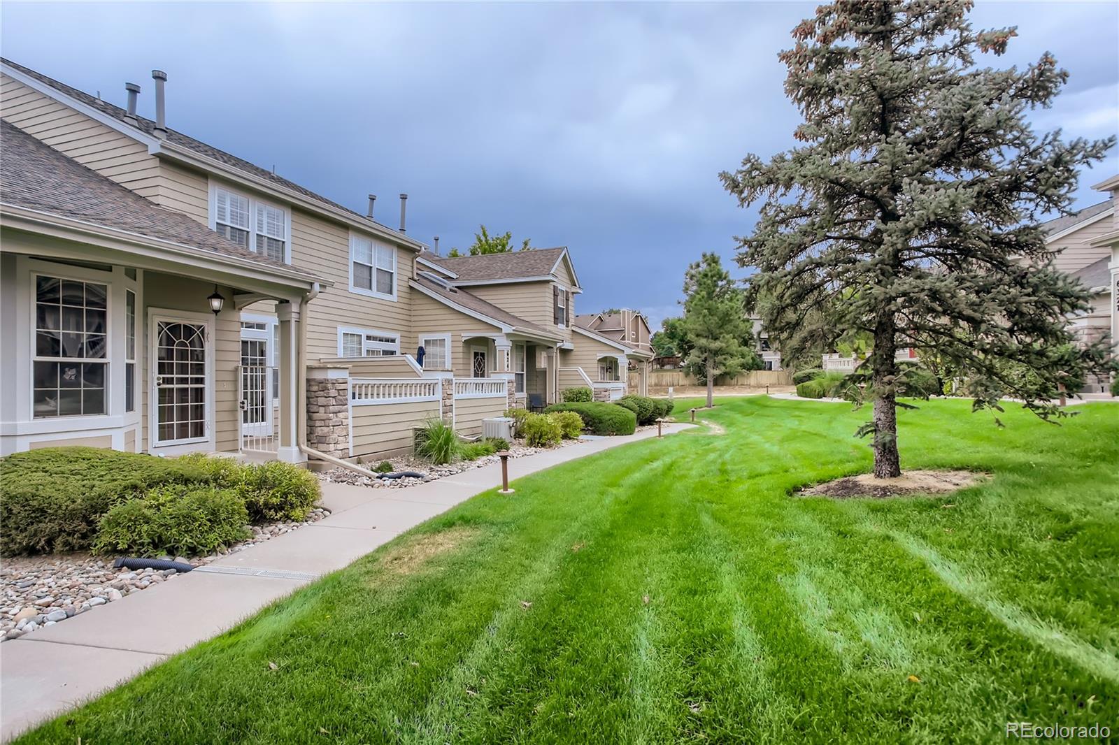 6247 Trailhead Road Highlands Ranch, CO 80130 - Photo 3 of 28 a front view of a house with a yard and trees