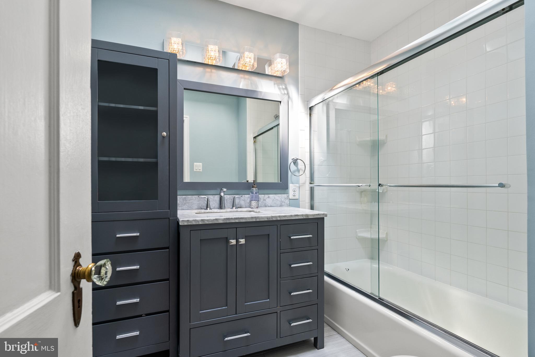 1511 44th Street Northwest Washington, DC 20007 - Photo 20 of 37 a bathroom with a shower sink vanity and mirror