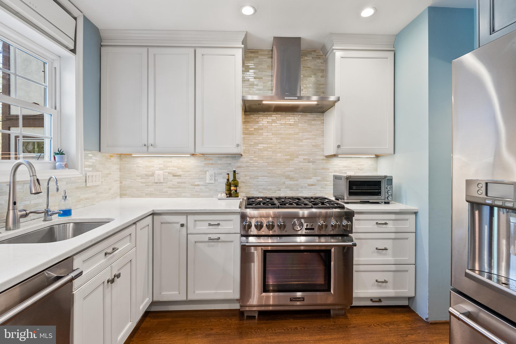 1511 44th Street Northwest Washington, DC 20007 - Photo 10 of 37 a kitchen with white cabinets and appliances