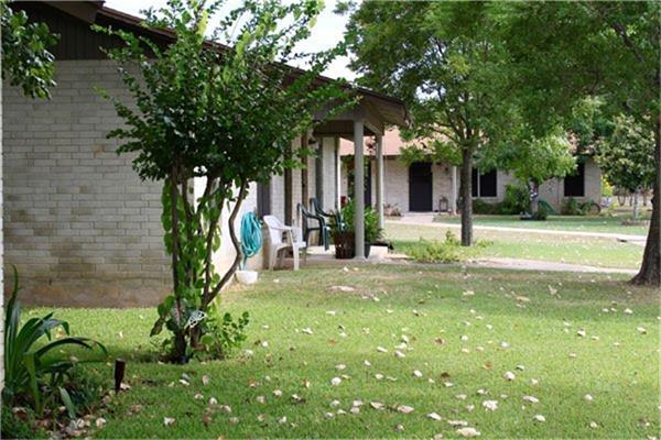 221 Peach Street Luling, TX 78648 - Photo 1 of 6 a view of a house with a tree in a yard