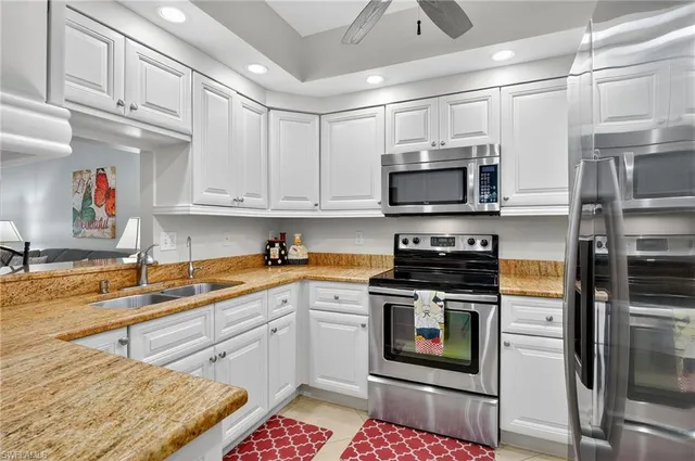 a kitchen with stainless steel appliances granite countertop a stove a sink and a microwave