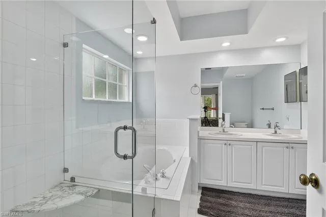 a bathroom with a double vanity sink a large mirror and shower