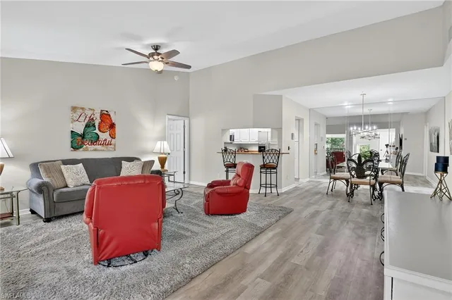 a living room with furniture and a dining table with wooden floor